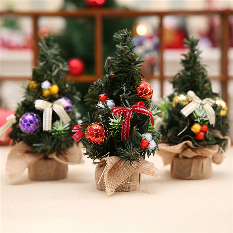 three small christmas trees with hessian pots on a table